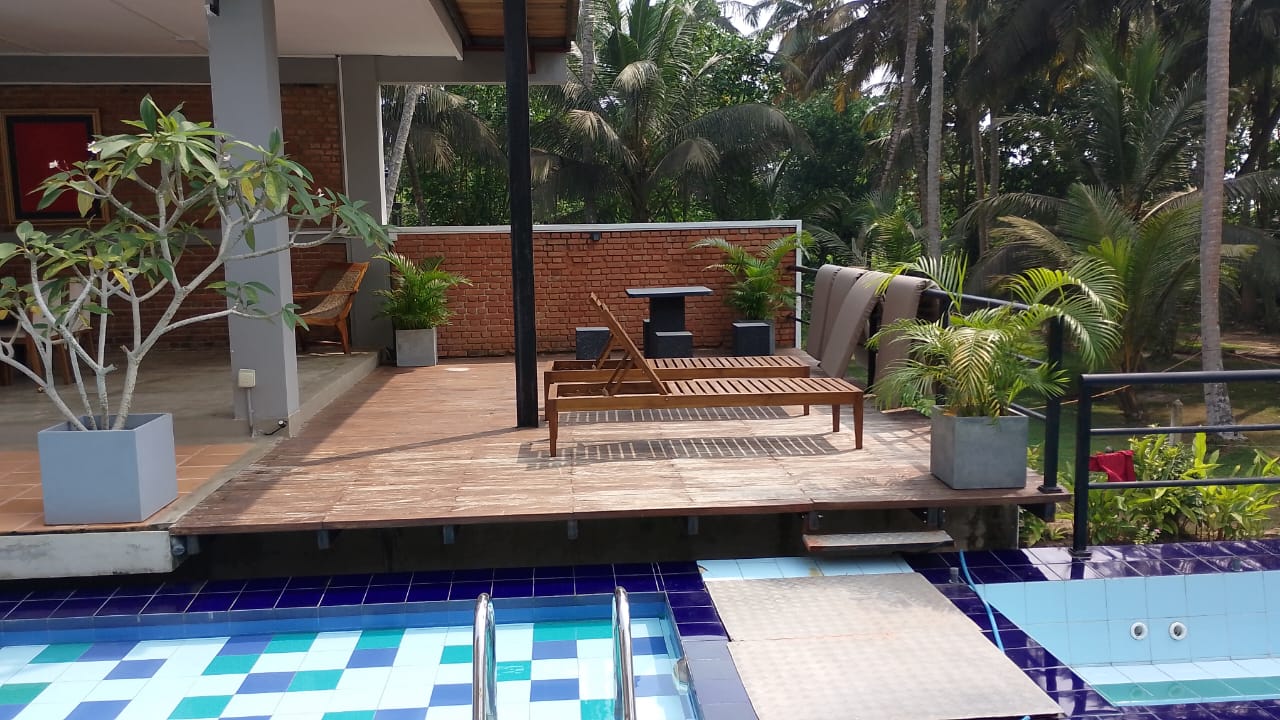 Large wooden breakfast dining table beside the 60ft infinity pool at Ko Lake Villa